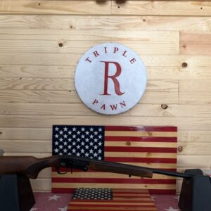 Shotgun displayed with American flags and pawn shop sign