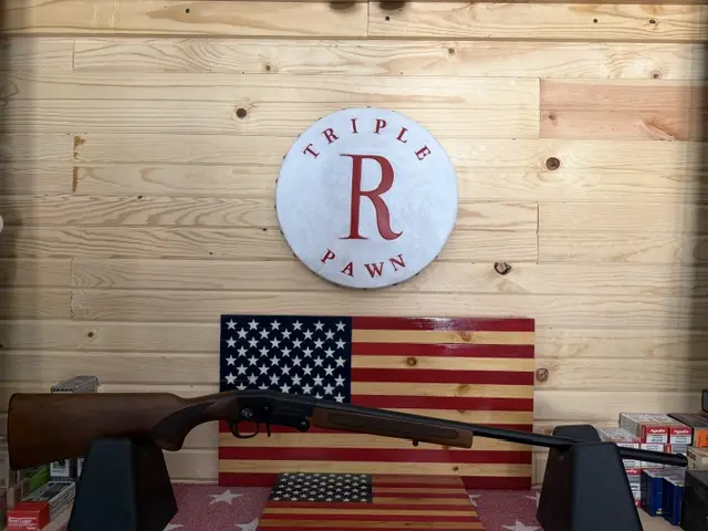 Shotgun displayed with American flags and pawn shop sign