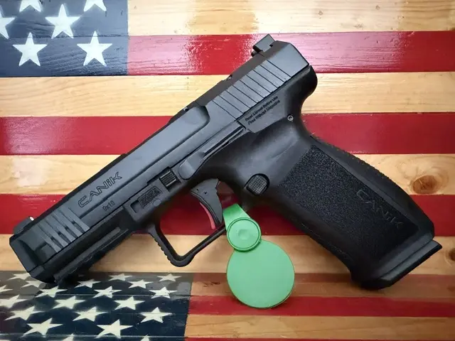Black handgun on wooden American flag background