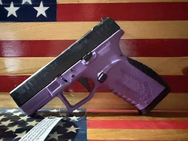 Purple handgun displayed against American flag background