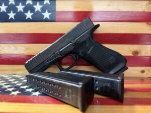 Handgun and magazine on wooden American flag