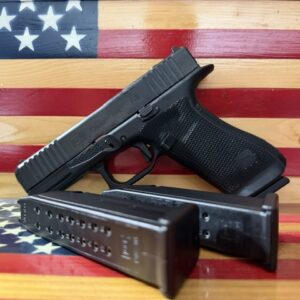 Handgun and magazine on wooden American flag