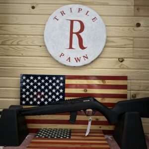 Black rifle displayed before American flag and pawn shop sign