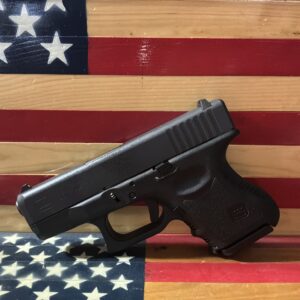 Black semi-automatic handgun displayed before an American flag